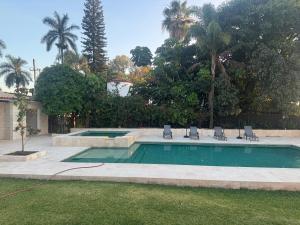 a swimming pool with chairs in a yard at Villa Marines Cuernavaca in Cuernavaca
