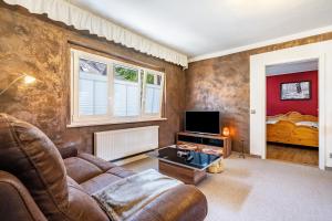 a living room with a couch and a tv at Ferienhaus Unterm Schloss in Bautzen