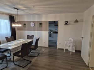 a dining room and living room with a table and chairs at Neu 4 Zi Kü Bad Coll-mar in Neunkirchen