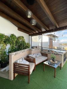 a patio with two beds and a table and plants at La morena in Guaro