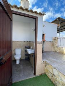 a bathroom with a toilet and a sink at La morena in Guaro +17 photos