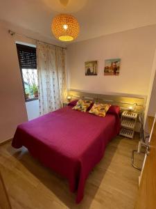 a bedroom with a large bed with a purple bedspread at La morena in Guaro