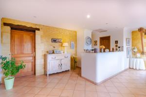 a large room with a counter and a door at La Noyeraie - Chambre d'hotes in Saint-Amand-de-Coly +25 photos
