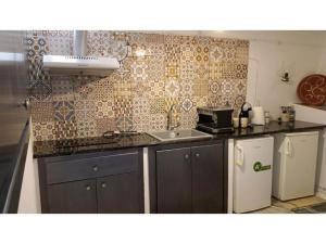 a kitchen with a sink and a refrigerator at Seagull Syros Seaside in Ermoupoli