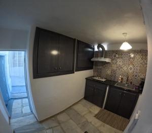 a kitchen with dark brown cabinets and a sink at Seagull Syros Seaside in Ermoupoli +18 photos