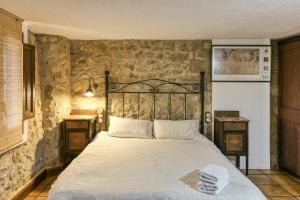 a bed in a room with a stone wall at Habitacions Mas Fuselles in Girona +145 photos