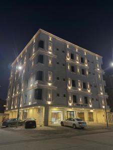 a large building with cars parked in a parking lot at توليب حتا 2 Tulip Hatta in Al Khobar