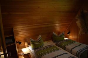 two beds in a room with a wooden wall at Hubertushütte in Kurort Oberwiesenthal
