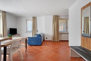 a living room with a table and a blue chair at Casa Colìn in Bresimo