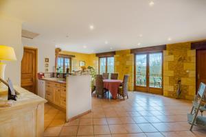 a kitchen with a table and a dining room at La Noyeraie - Chambre d'hotes in Saint-Amand-de-Coly