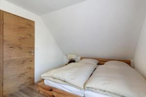 a bedroom with a bed with white sheets and a wooden door at Caroline Magg in Lindau