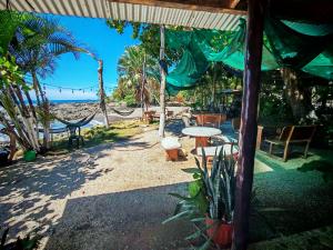 a patio with a table and chairs and the beach at Hotel Lucy in Montezuma