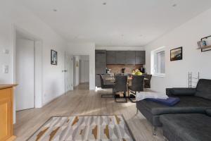 a living room with a couch and a dining room at Seelenwärmerstuuv in Kronprinzenkoog +20 photos