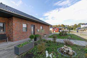 a brick house with a garden in front of it at Seelenwärmerstuuv in Kronprinzenkoog