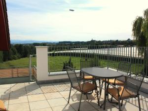 a patio with a table and chairs on a balcony at Ferienwohnungen Pano in Friedrichshafen