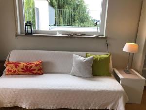 a bed with four pillows in a room with a window at Ferienwohnungen Pano in Friedrichshafen