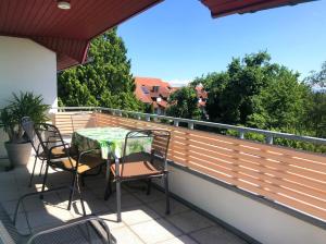 a patio with a table and chairs on a balcony at Ferienwohnungen Pano in Friedrichshafen +18 photos