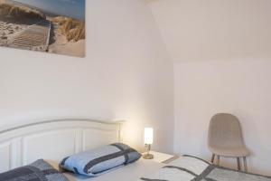 a bedroom with a bed with a lamp and a chair at Ferienwohnung Hennen in Witzenhausen