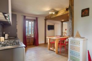 a kitchen with a table and a kitchen with a stove at Appartamento Pila Vacanze in Gressan