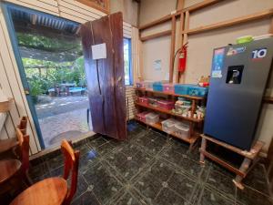 a kitchen with a refrigerator and a table with a window at Hotel Lucy in Montezuma