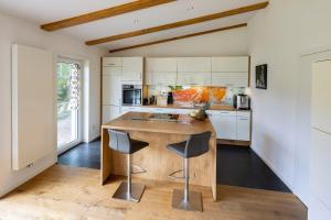 a kitchen with a wooden island with two bar stools at Ferienhaus Chalet Bergblick in Stryck +22 photos