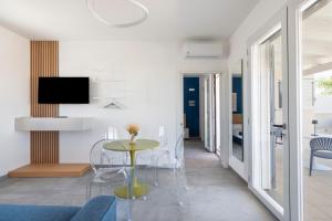 a living room with a table with chairs and a tv at Briamar Residence in Torre dell'Orso