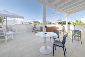 a patio with tables and chairs and an umbrella at Briamar Residence in Torre dell'Orso