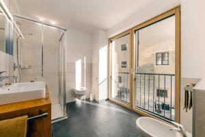 a bathroom with a sink and a toilet and a balcony at Untermoarhof Albeins in Bressanone +27 photos