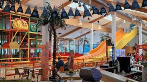 a restaurant with an indoor playground with a slide at Bayerwaldresort in Sankt Englmar