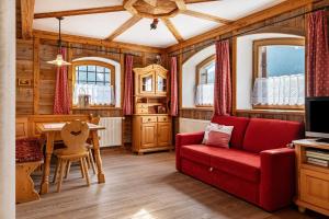 a living room with a red couch and a table at Thomasegg Hof Birke in Sarntal