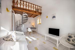 a living room with a staircase and a television at Apartamento Amarelo T1 in Odeceixe