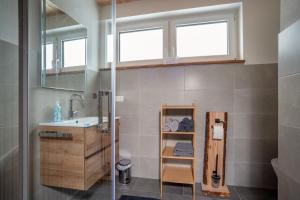 ein Badezimmer mit Waschbecken, Spiegel und Fenster in der Unterkunft Ferienhaus Tiny Time in Krumbach + 10 Fotos