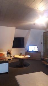 a living room with a table and a tv at Ferienwohnung Hiddenseeblick 2 in Dranske +11 photos