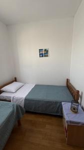 a room with two beds and a table in it at Laura Apartment in Tribunj