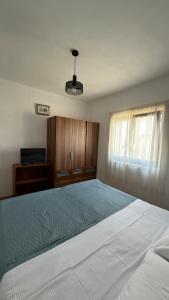 a bedroom with a large white bed and wooden cabinets at Laura Apartment in Tribunj