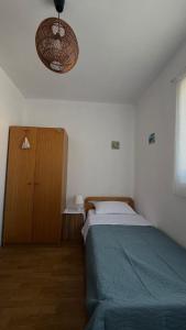 a bedroom with a bed and a wooden cabinet at Laura Apartment in Tribunj +9 photos
