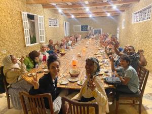 a group of people sitting at a long table at King Siwa in Siwa