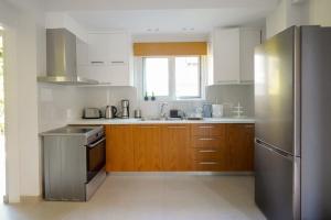 a kitchen with wooden cabinets and a stainless steel refrigerator at Casa Marjeta in Chania