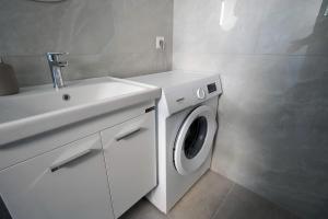 a white bathroom with a washing machine and a sink at Casa Marjeta in Chania
