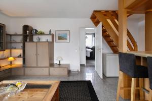 a living room with white walls and a wooden table at Sylt Ferienwohnung 4 Westerland in Westerland +15 photos
