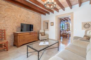 a living room with a couch and a tv at S'era in Santanyi