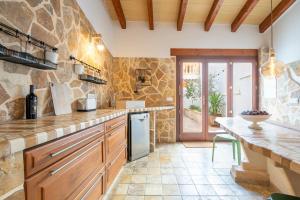 a large kitchen with a stone wall at Casa Sol y Luna in Artá