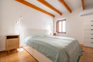 a white bedroom with a bed and a window at Casa Sol y Luna in Artá