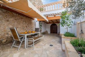 a patio with a table with chairs and an umbrella at Casa Sol y Luna in Artá