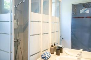 a bathroom with a sink and a shower with a mirror at Vacances Pays Basque in Bidart