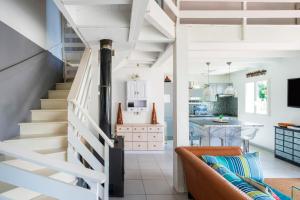 a white staircase in a living room with a kitchen at Vacances Pays Basque in Bidart