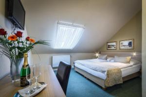 Schlafzimmer mit einem Bett und einem Tisch mit einer Flasche Champagner in der Unterkunft Hotel Taurus in Prag