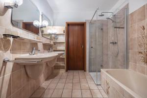 a bathroom with a tub and a sink and a shower at Ferienhaus Timm in Meldorf +23 photos