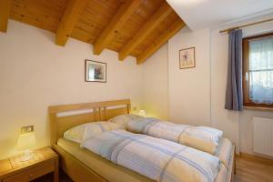 two beds in a room with wooden ceilings at Inneroswalderhof in Anterselva di sotto