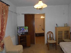 a living room with a television and a bedroom at Giorgio in Kritsa